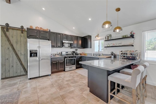 kitchen with open shelves, hanging light fixtures, appliances with stainless steel finishes, a peninsula, and a kitchen breakfast bar