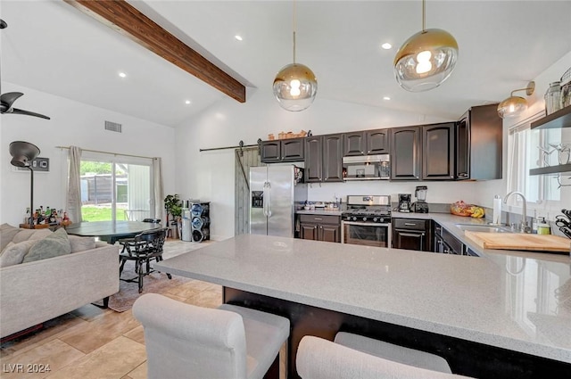 kitchen with a barn door, stainless steel appliances, a sink, visible vents, and light countertops