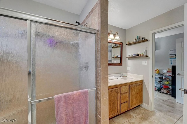 bathroom featuring double vanity, a stall shower, and a sink