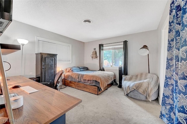 bedroom with a textured ceiling, carpet, and visible vents