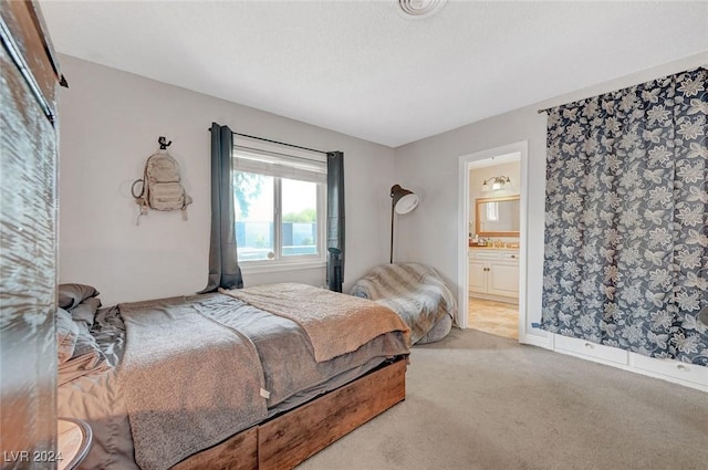 bedroom featuring ensuite bath and light colored carpet