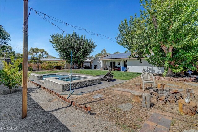 view of yard with an in ground hot tub and a patio area