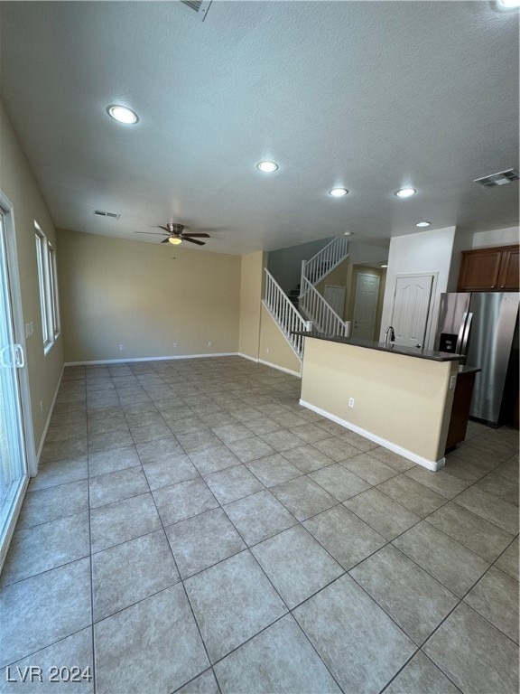 interior space with ceiling fan, light tile patterned floors, and sink