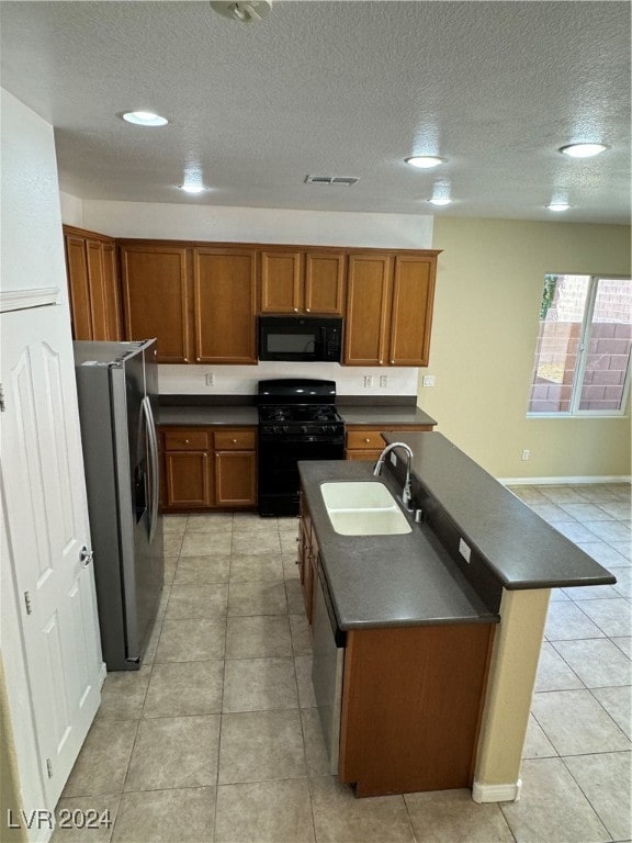 kitchen featuring a textured ceiling, light tile patterned flooring, sink, kitchen peninsula, and black appliances