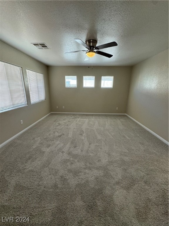 carpeted empty room with a textured ceiling and ceiling fan