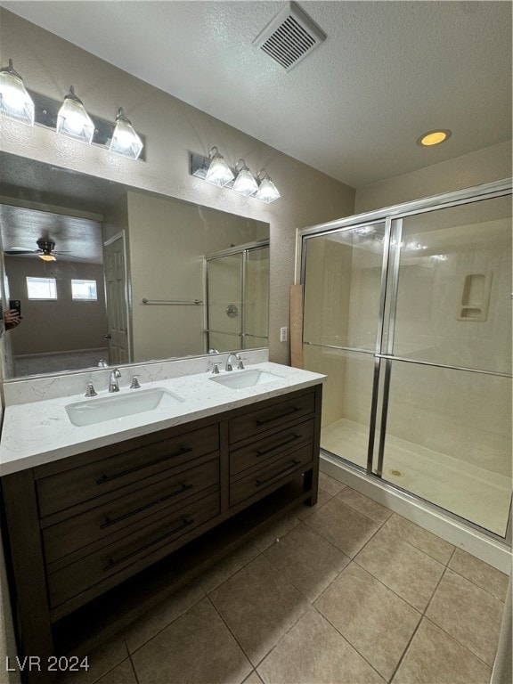 bathroom with tile patterned flooring, ceiling fan, a shower with shower door, and vanity