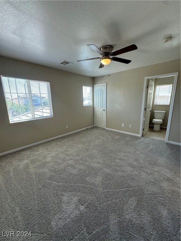 interior space with a textured ceiling, light carpet, and ceiling fan