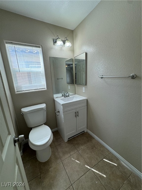 bathroom with tile patterned flooring, vanity, and toilet