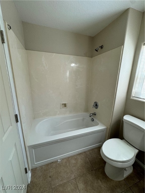 bathroom featuring shower / bathing tub combination, a textured ceiling, toilet, and tile patterned floors