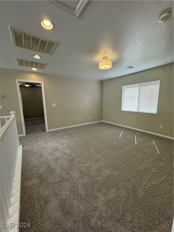 spare room with a textured ceiling and carpet flooring