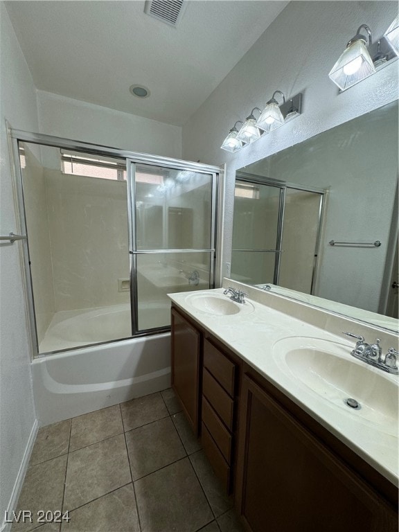 bathroom with combined bath / shower with glass door, vanity, and tile patterned floors