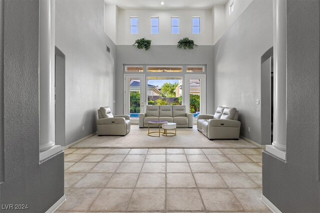 living room with a towering ceiling and decorative columns