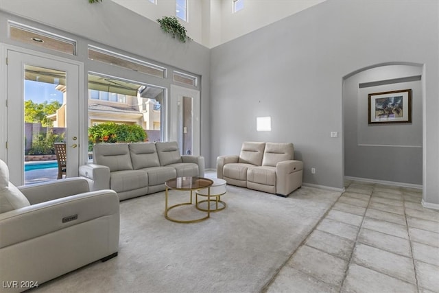 living room with a towering ceiling and french doors