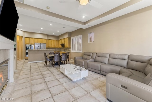 living room featuring ceiling fan and a fireplace