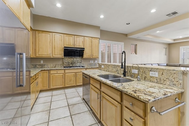 kitchen with dishwasher, light brown cabinets, light stone counters, and sink