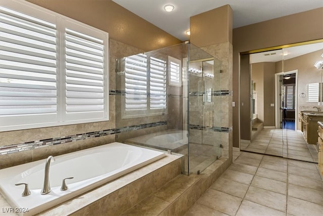 bathroom with tile patterned flooring, vanity, and plus walk in shower