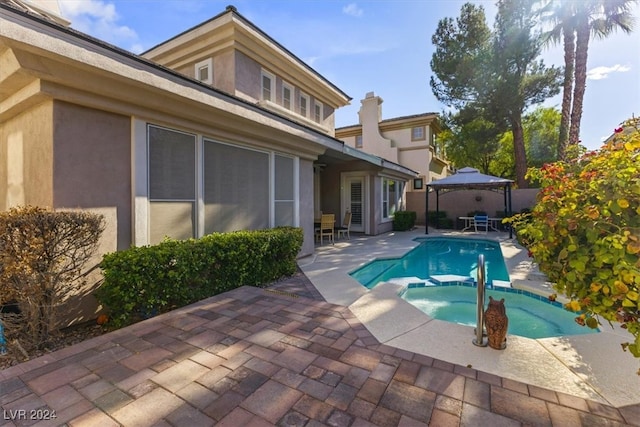 view of pool with a patio and an in ground hot tub