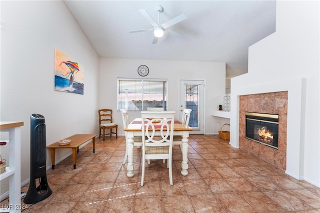 dining area with ceiling fan and a tile fireplace