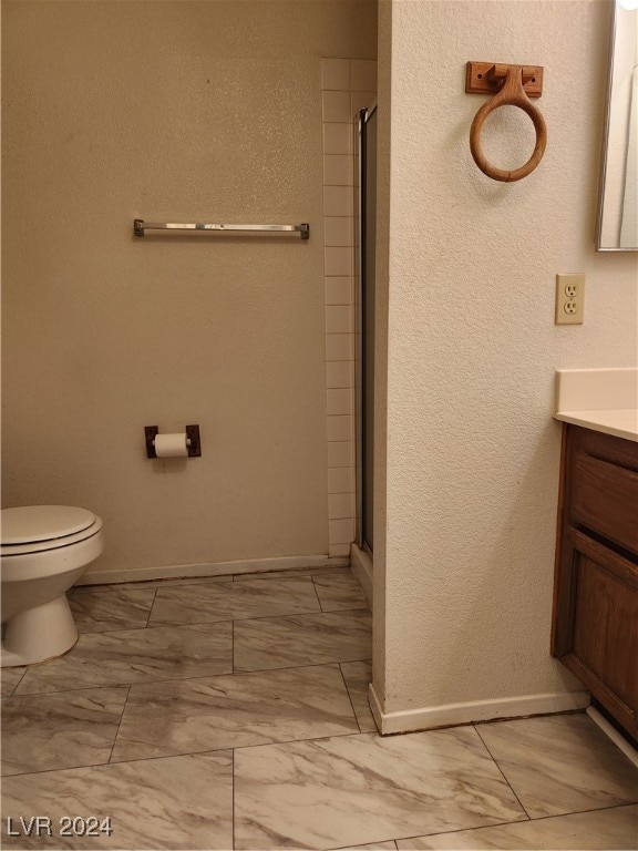 bathroom featuring walk in shower, vanity, and toilet