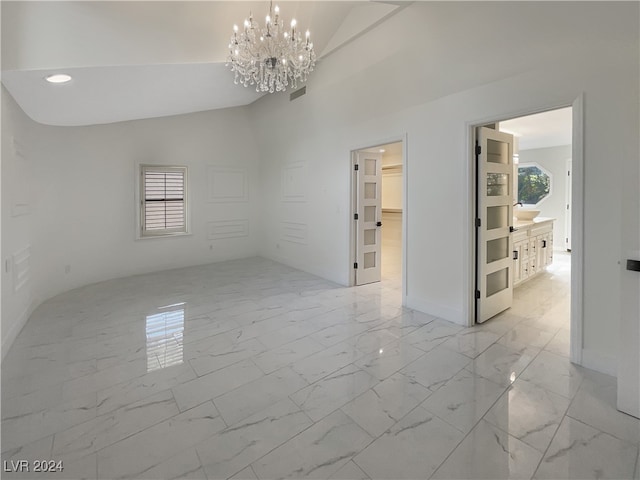 unfurnished room with a wealth of natural light, lofted ceiling, and an inviting chandelier