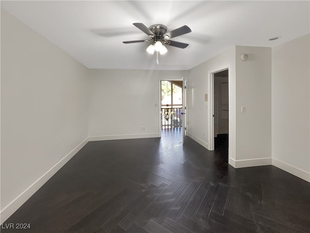 empty room featuring dark parquet flooring and ceiling fan