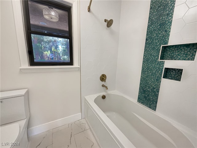 bathroom with toilet and tiled shower / bath combo