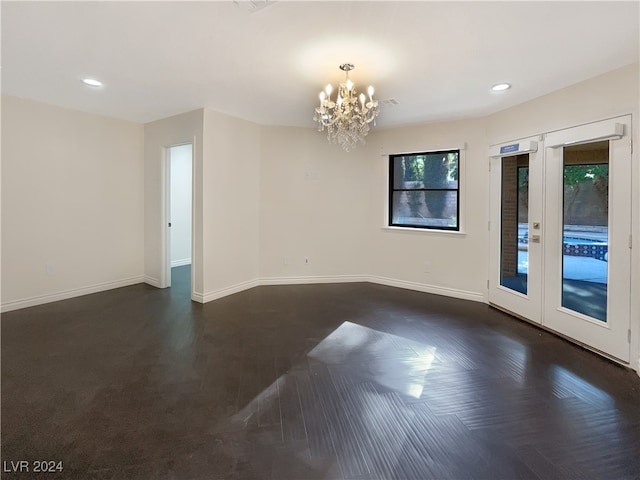 unfurnished room with a chandelier and dark parquet flooring