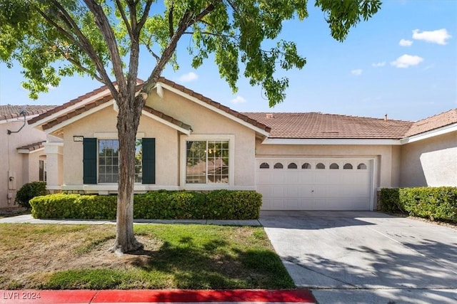 single story home with a tile roof, an attached garage, driveway, and stucco siding