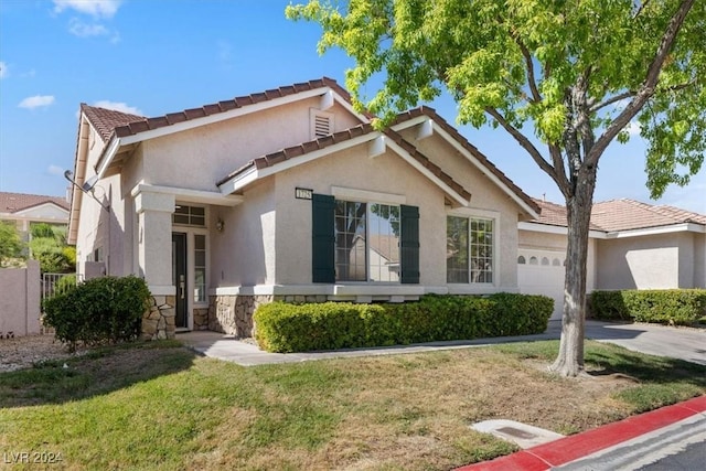 single story home with a garage, a tile roof, stucco siding, a front lawn, and driveway