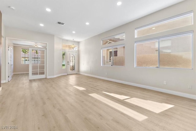 unfurnished living room featuring light wood-type flooring, a ceiling fan, visible vents, recessed lighting, and baseboards