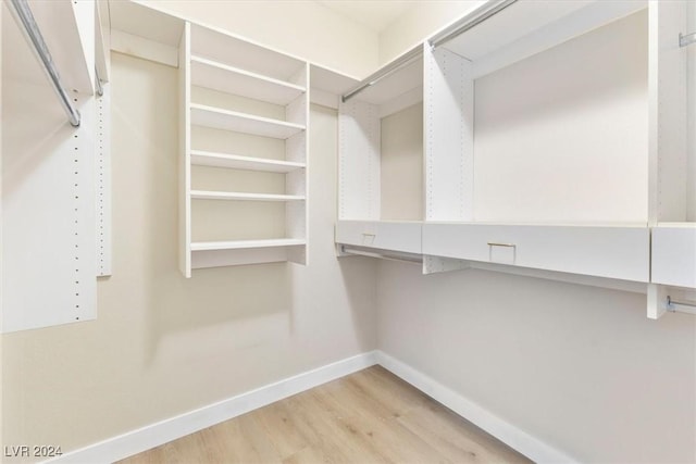 walk in closet with wood finished floors
