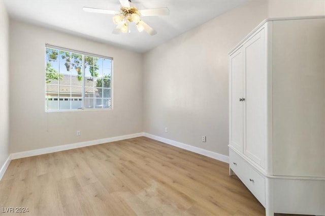 empty room featuring light wood-style flooring, ceiling fan, and baseboards