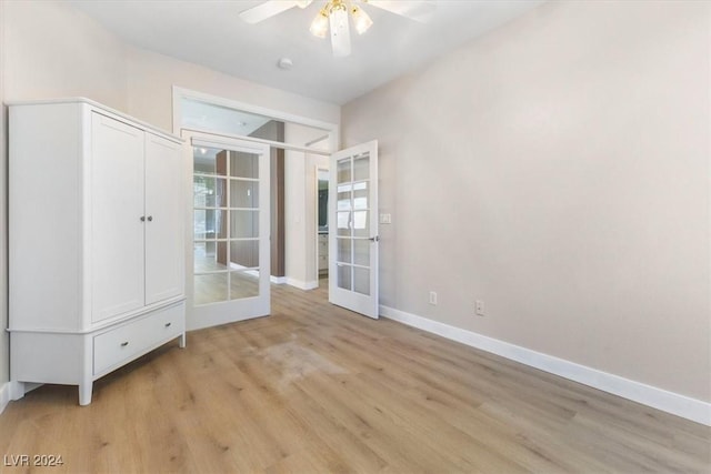 interior space with light wood-type flooring, french doors, ceiling fan, and baseboards