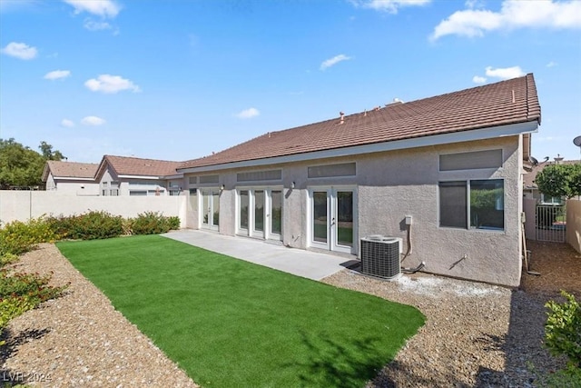 back of house featuring a yard, a fenced backyard, cooling unit, a patio, and stucco siding