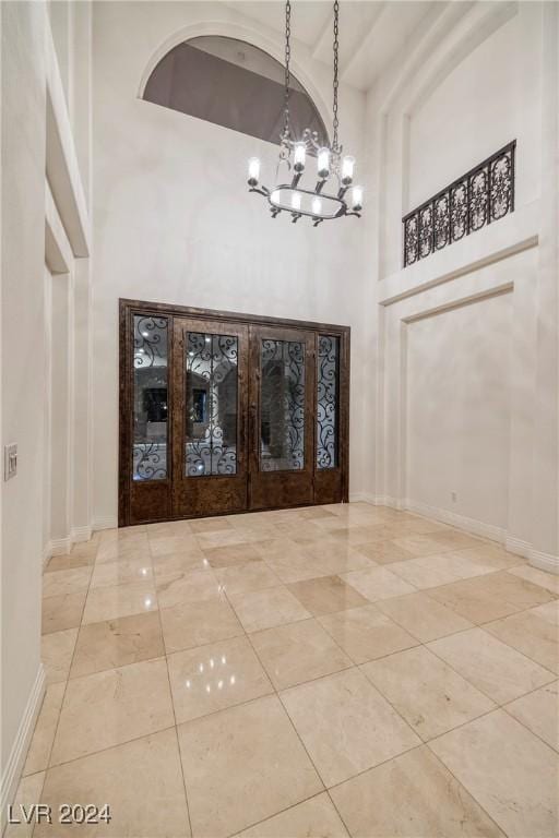 7421 Silver Palm Ave, Las Vegas, NV 89117 - foyer with a high ceiling, tile patterned flooring, a notable chandelier, and baseboards