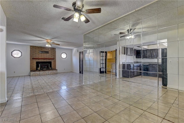 4842 E Imperial Ave, Las Vegas, NV 89104 - unfurnished living room featuring ceiling fan, a fireplace, a textured ceiling, and tile patterned floors
