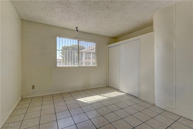 4842 E Imperial Ave, Las Vegas, NV 89104 - unfurnished dining area featuring a textured ceiling and light tile patterned floors
