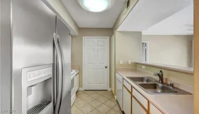 kitchen with light tile patterned flooring, sink, and white appliances