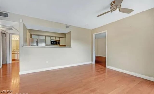 unfurnished living room featuring ceiling fan and light wood-type flooring