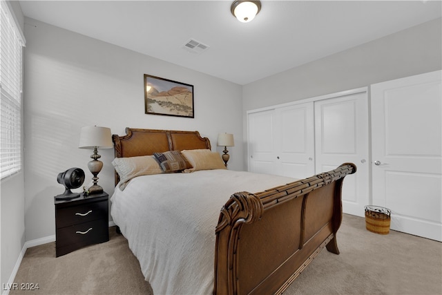 bedroom with light colored carpet and a closet