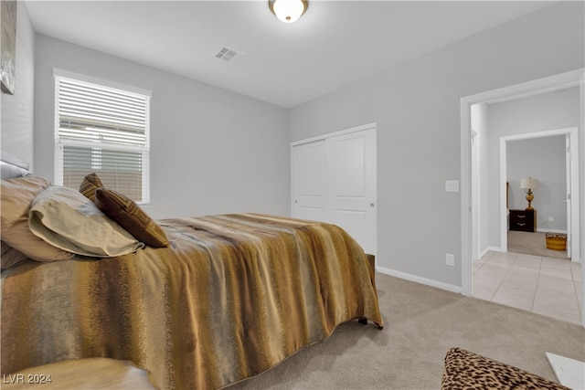 bedroom featuring light carpet and a closet