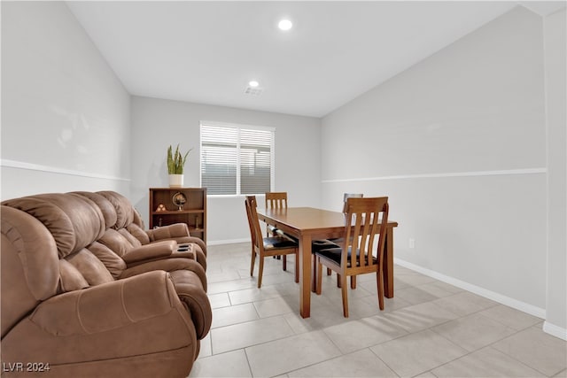 dining space featuring light tile patterned floors and lofted ceiling