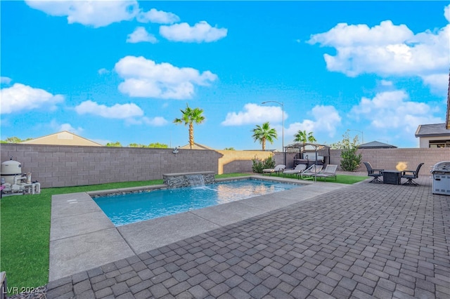 view of swimming pool with pool water feature and a patio