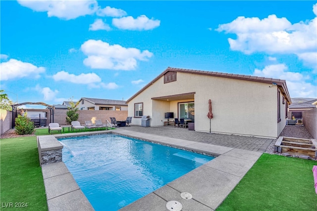 view of swimming pool with a yard, a patio, and pool water feature