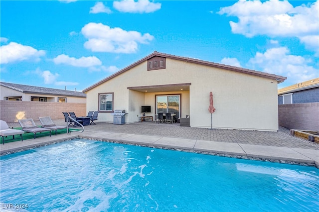 view of swimming pool featuring area for grilling and a patio area