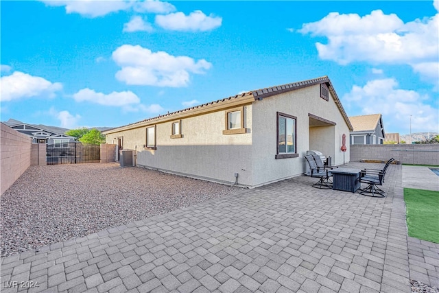 rear view of property featuring a patio and cooling unit