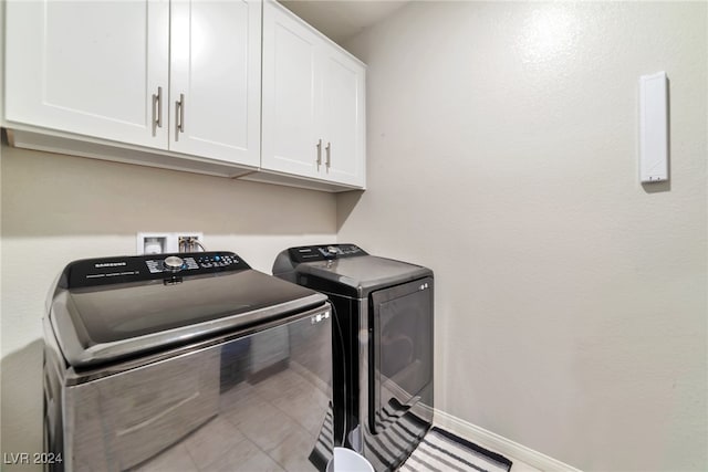 laundry room featuring cabinets and washing machine and clothes dryer