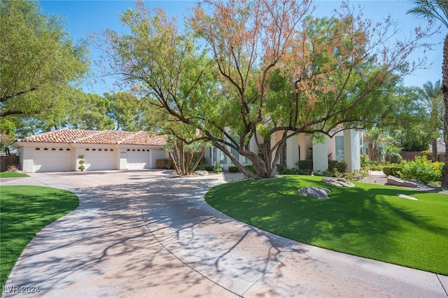 mediterranean / spanish home featuring a front lawn and a garage