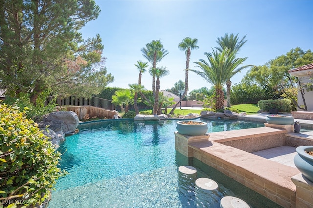 view of swimming pool featuring pool water feature and a jacuzzi