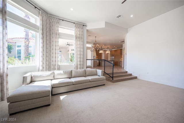 living room with carpet floors and ceiling fan with notable chandelier